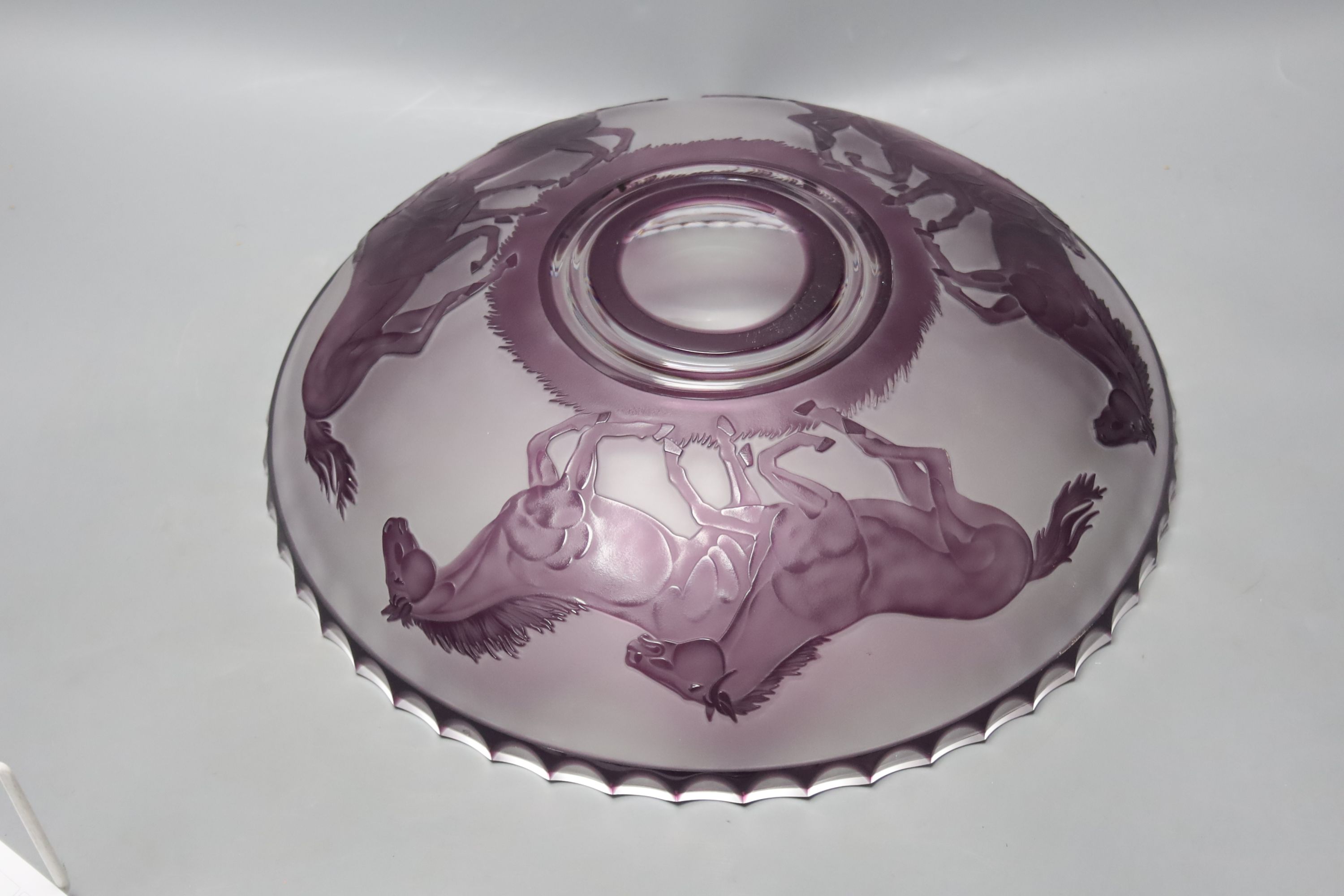An amethyst overlaid glass fruit bowl, decorated with horses, height 34cm